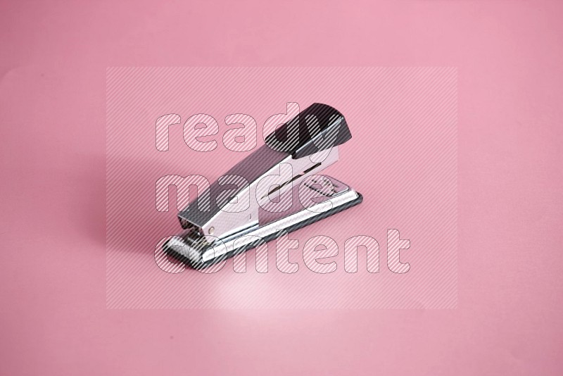 A metal stapler on rose background in different  angles (back to school)
