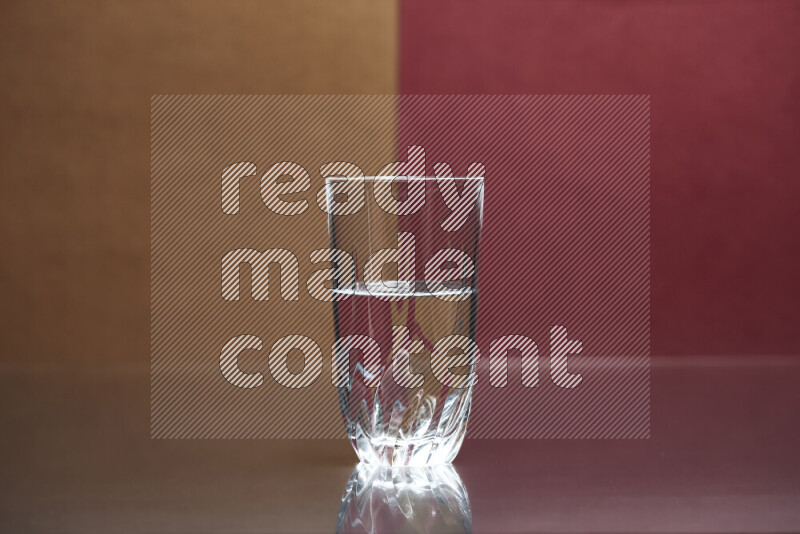 The image features a clear glassware filled with water, set against brown and dark red background