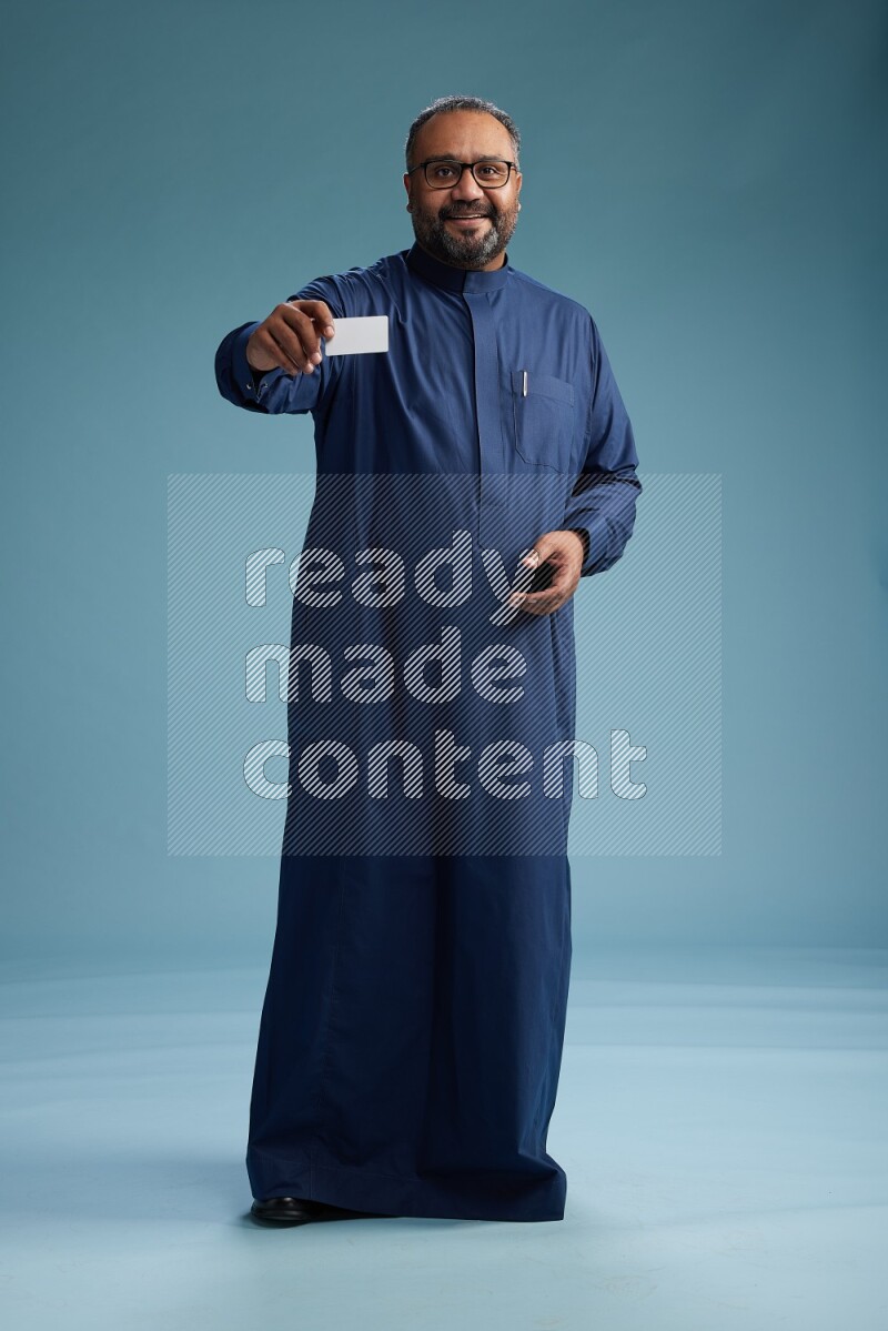 Saudi Man without shimag Standing holding ATM on blue background