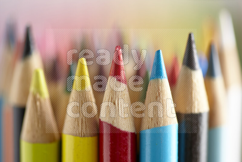 The image captures a close-up of sharpened colored pencils on multicolored background