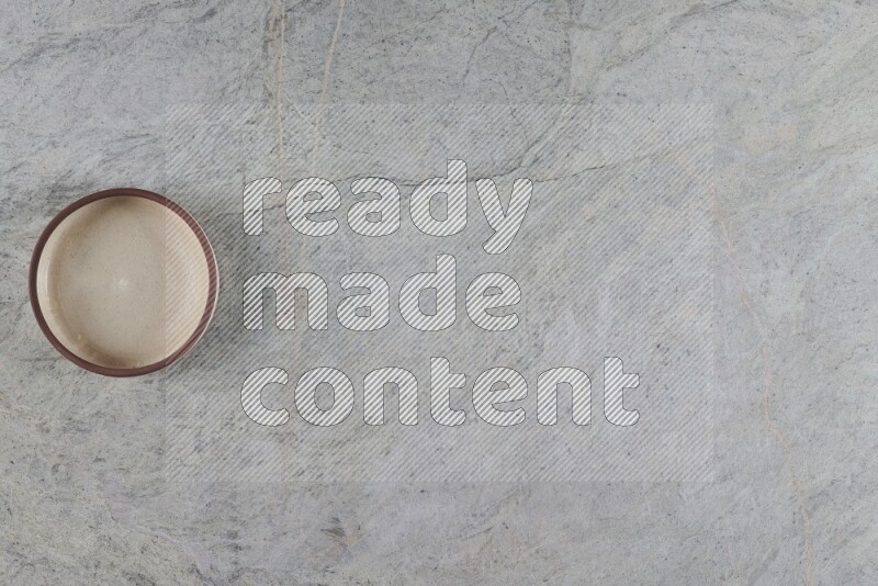 A multicolored pottery oven bowl on grey marble background