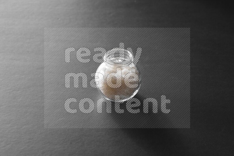 ملح في وعاء زجاجي علي خلفية سوداء