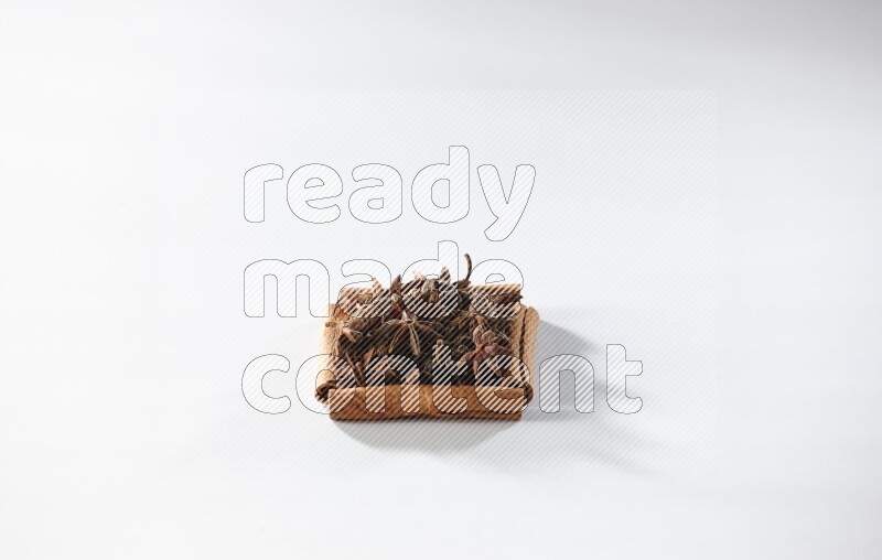 أربعة من أعواد القرفة مكونة شكل مربع بداخلها يانسون نجمي علي خلفية بيضاء