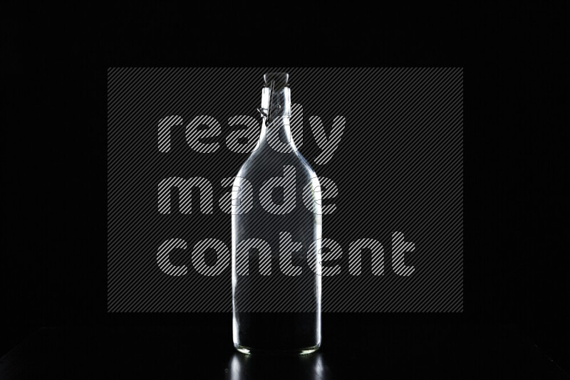 Water bottle with colored rim light against black background