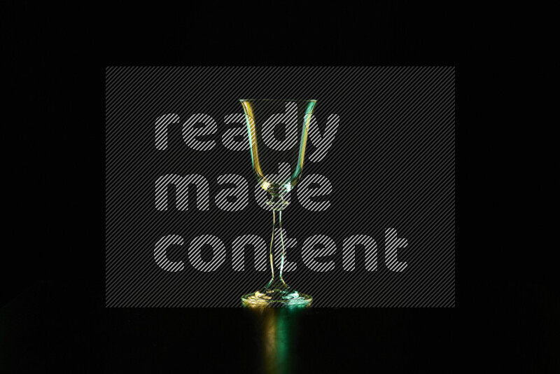 Glassware with rim light in green and yellow against black background