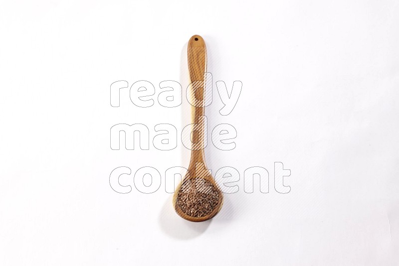 A wooden ladle full of flax on a white flooring in different angles