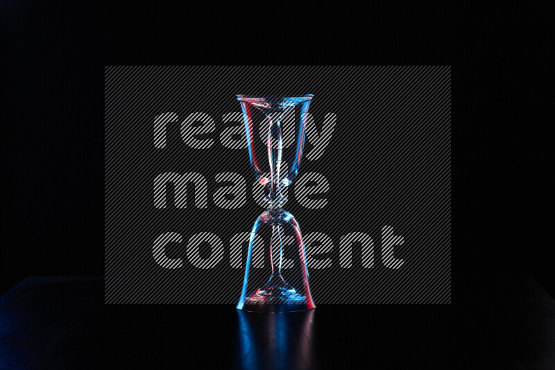 Glassware with rim light in red and blue against black background