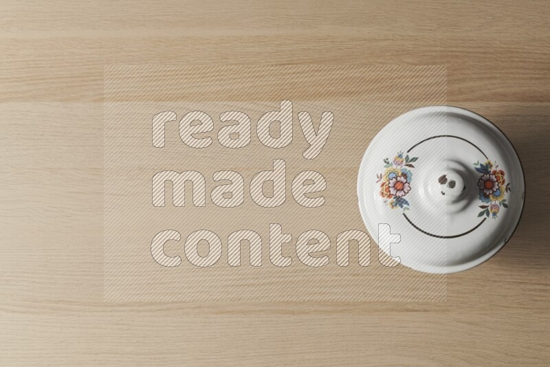 وعاء عتيق معدني على خلفية خشبية فاتحة