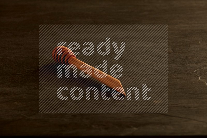 Wooden honey dipper on black slate background