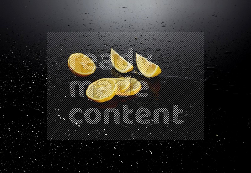 Lemon slices with water drops, and droplets on black background