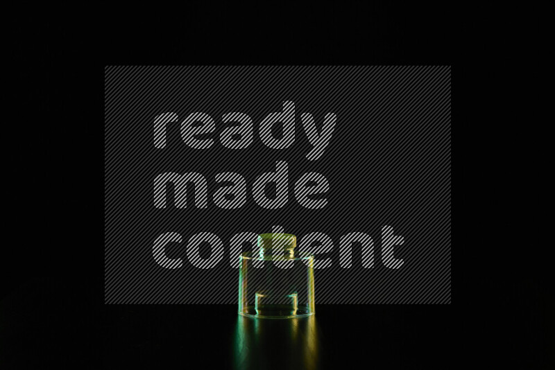 Glassware with rim light in green and yellow against black background