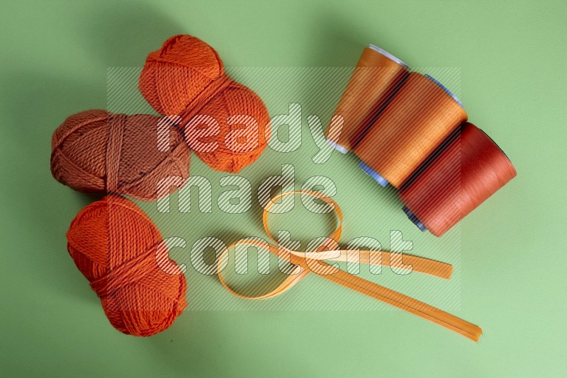 Orange sewing supplies on green background