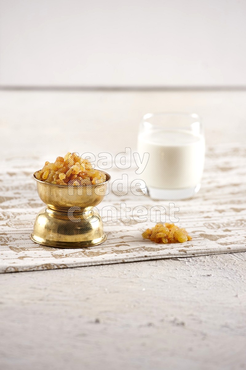 Dried fruits in a metal bowl with milk in a light setup