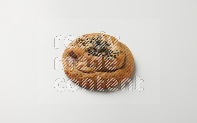 Hasawi cookie field with date and decorated by black seed and Anise grain on a white background