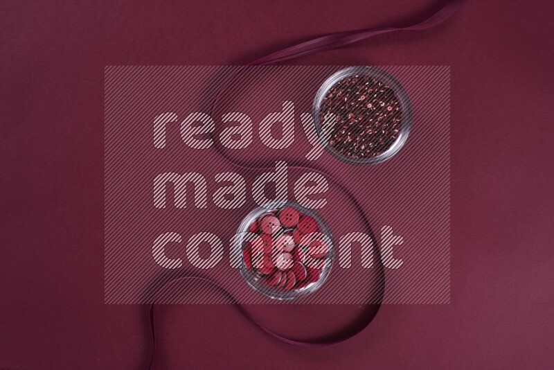 مجموعة من أدوات الخياطة والتفصيل حمراء اللون على خلفية حمراء