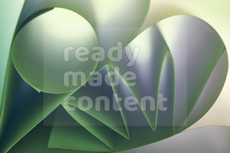 عرض فني لطيات الورق تخلق مزيج من الأشكال الهندسية، مضاءة بإضاءة ناعمة بدرجات اللون الأخضر والأحمر