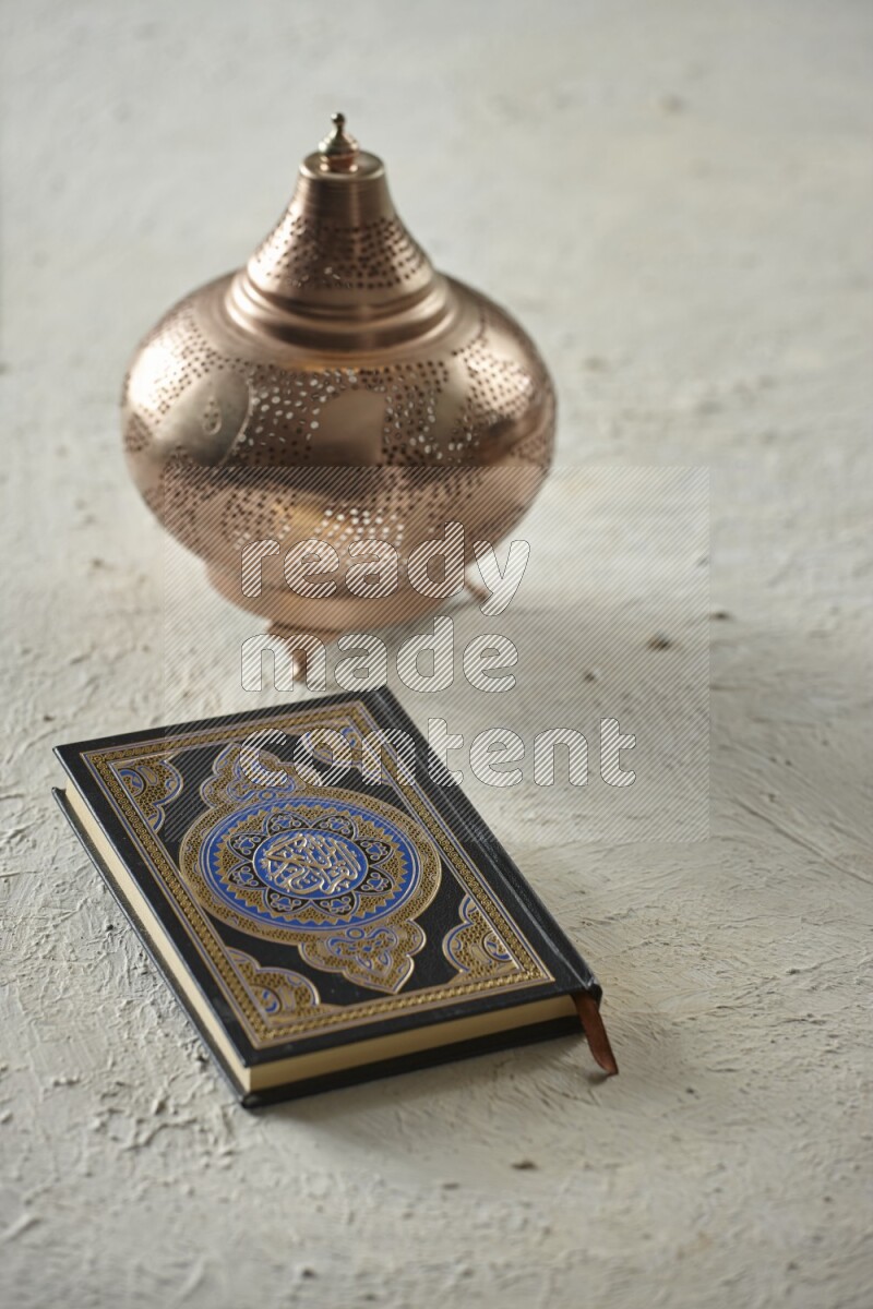 A golden lantern with different drinks, dates, nuts, prayer beads and quran on textured white background