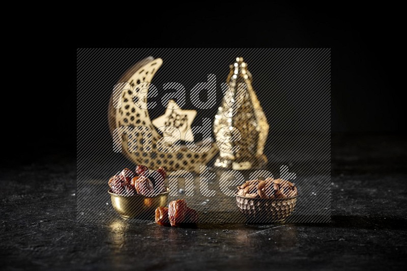 Dates in a metal bowl with almonds beside golden lanterns in a dark setup