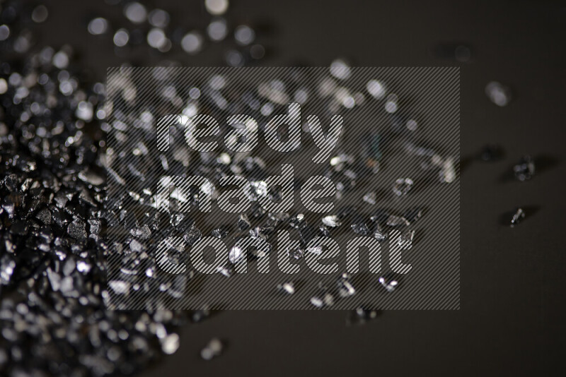 قطع زجاجية سوداء لامعة متناثرة على خلفية سوداء