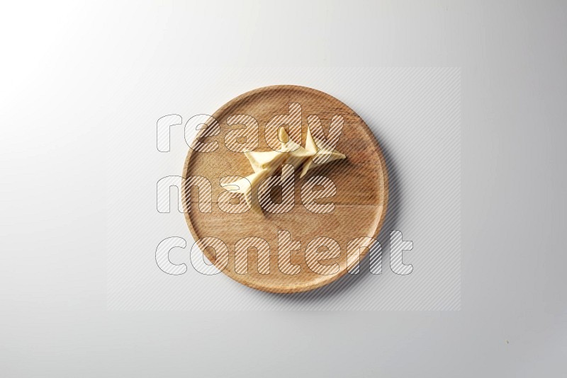 Four Sambosas on a wooden round plate on a white background