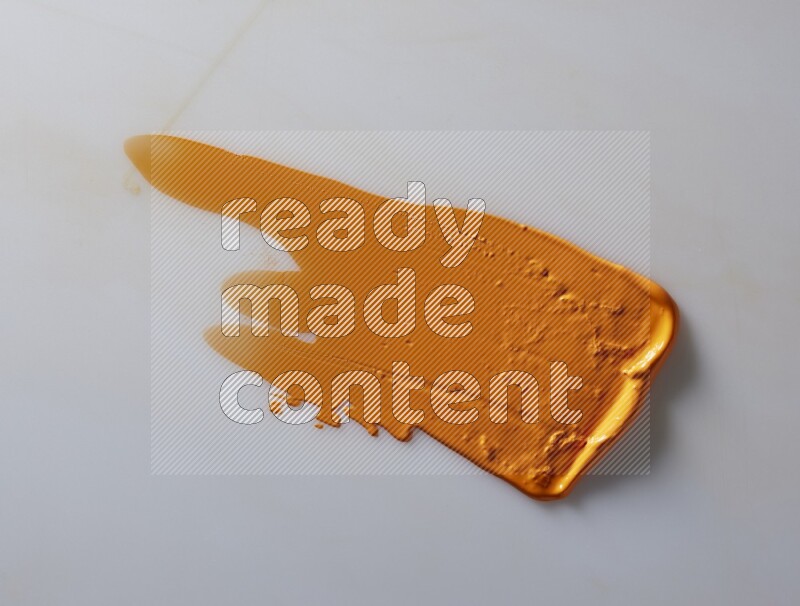An orange straight painting knife stroke on white background