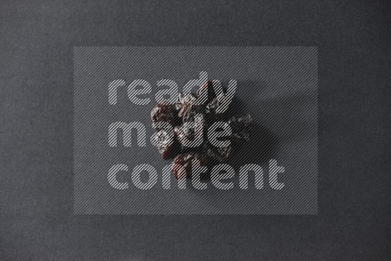 Dried plums on a black background in different angles