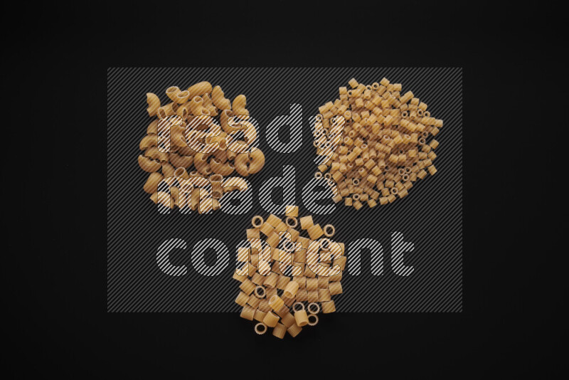 Different pasta types in bunches on black background