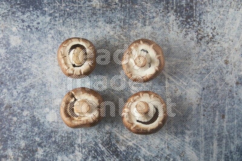 small fresh Cremini wood mushrooms topview on blue textured background