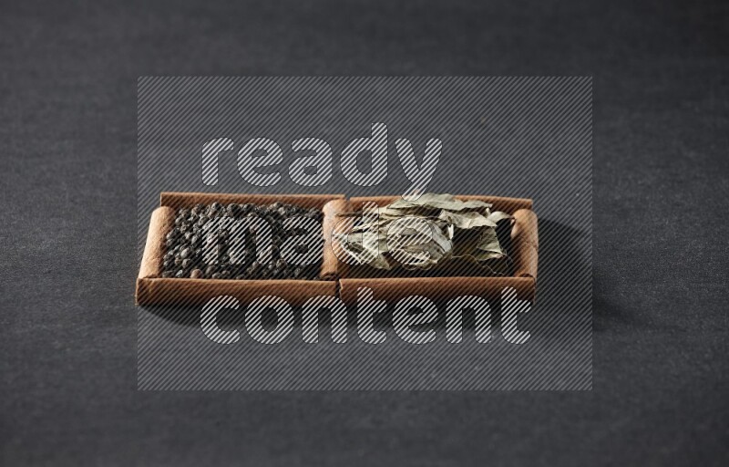 2 squares of cinnamon sticks full of black peppers and bay laurel leaves on black flooring