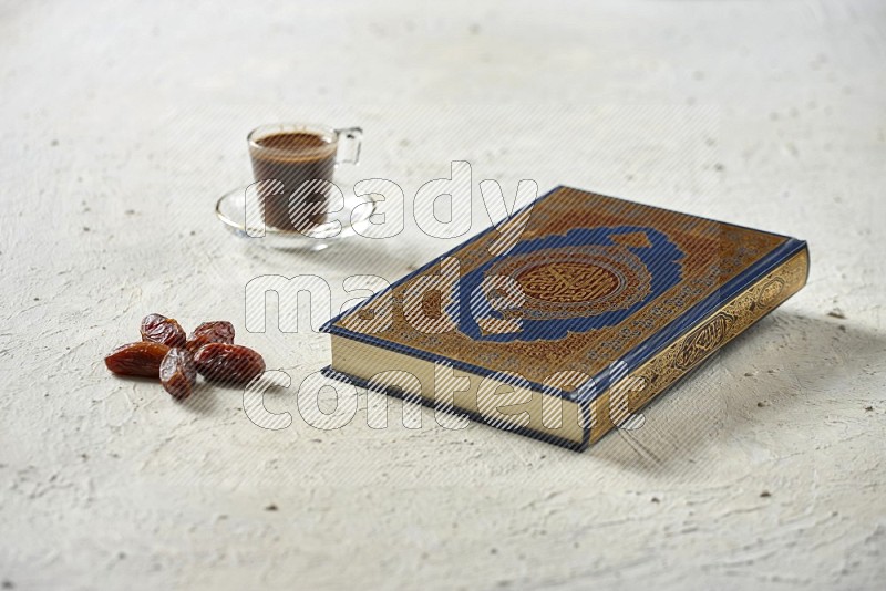 Quran with dates, prayer beads and different drinks on textured white background