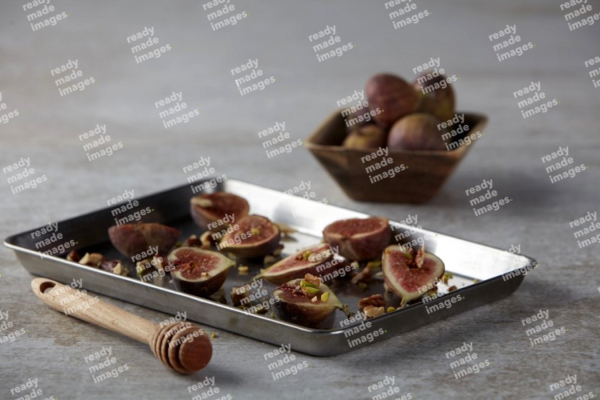 fresh figs on an oven tray on a textured grey background