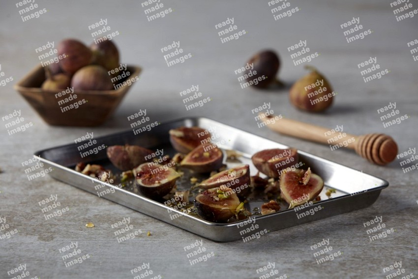 fresh figs on an oven tray on a textured grey background