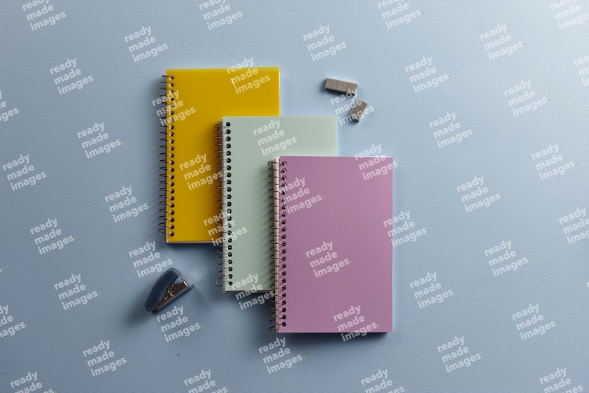A multicolored notebooks with school supplies on blue background (Back to school)