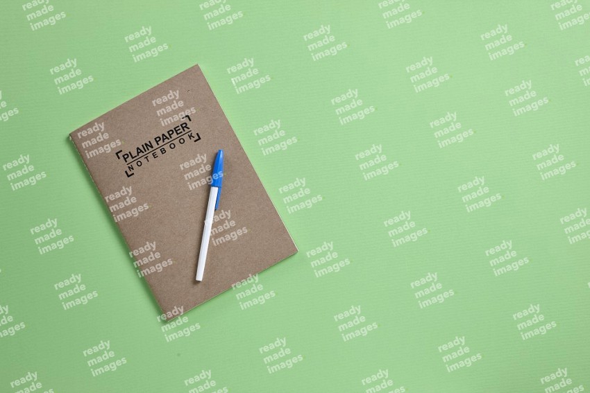 A notebook with school supplies on green background (Back to school)