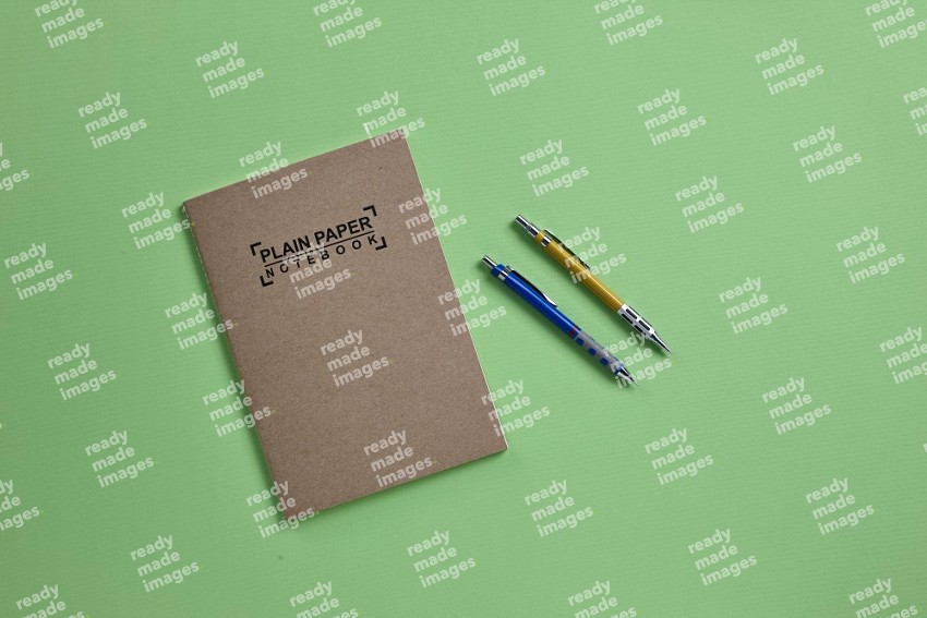 A notebook with school supplies on green background (Back to school)