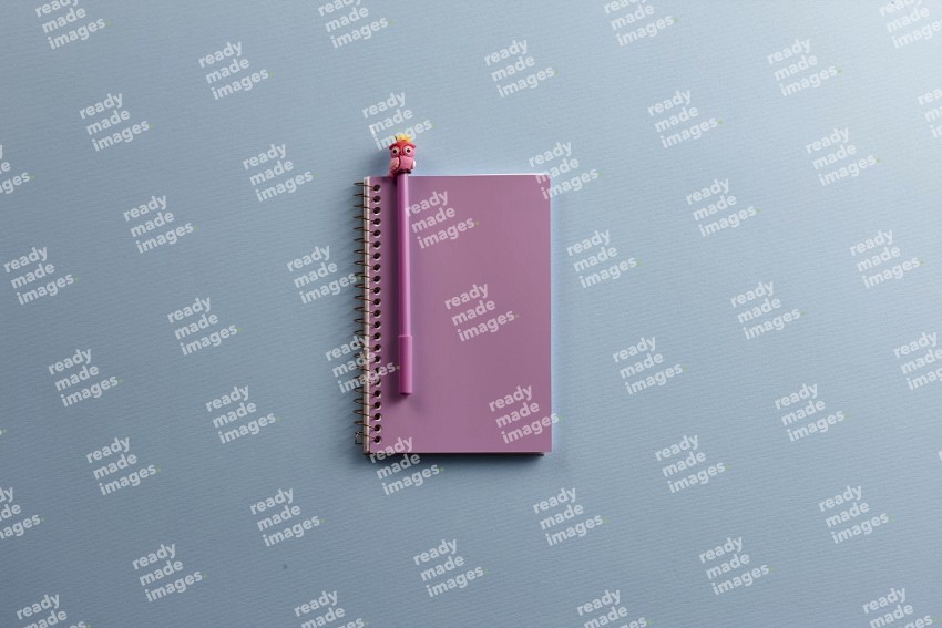 A purple notebook with school supplies on blue background (Back to school)