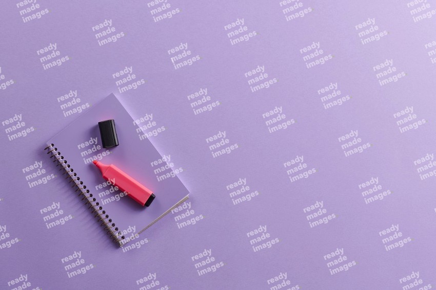 A purple notebook with school supplies on purple background (Back to school)