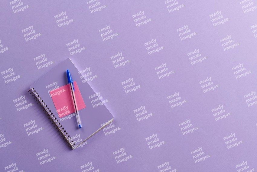 A purple notebook with school supplies on purple background (Back to school)