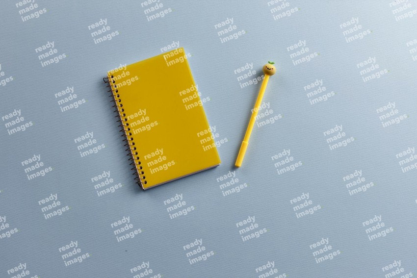 A yellow notebook with school supplies on blue background (Back to school)