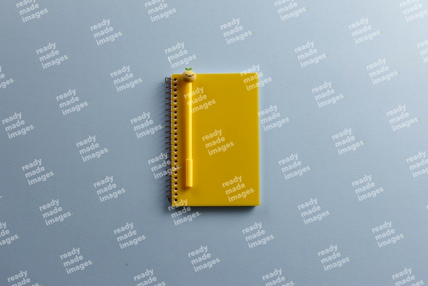 A yellow notebook with school supplies on blue background (Back to school)