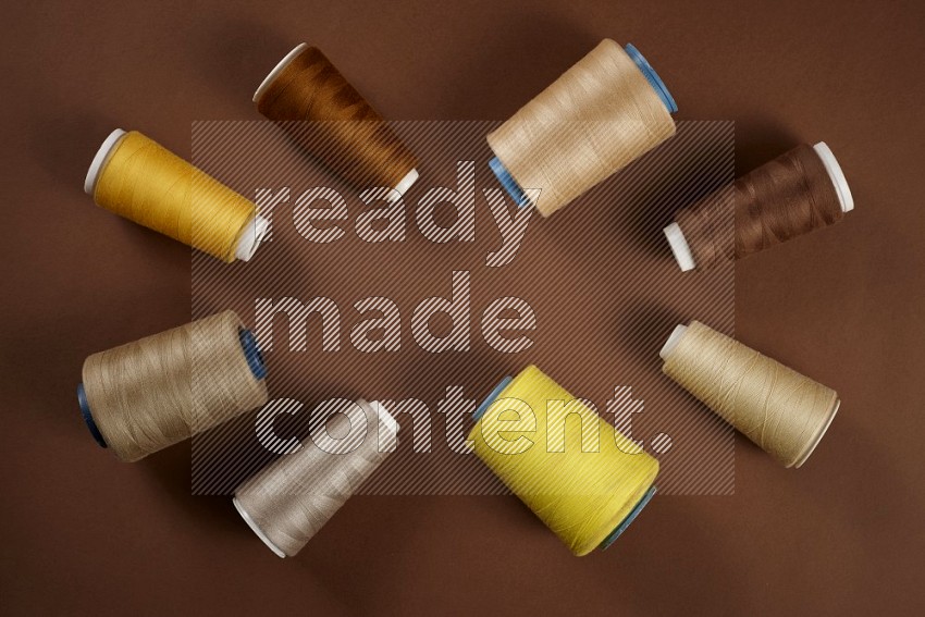 Yellow sewing supplies on brown background