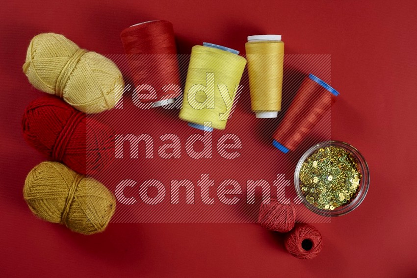Yellow sewing supplies on red background