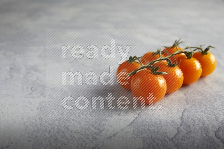 Orange cherry tomato vein on a light grey textured background 45 degree