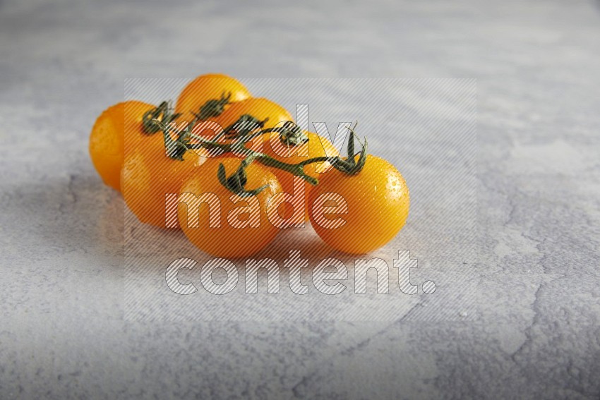 Yellow cherry tomato vein on a light grey textured background 45 degree