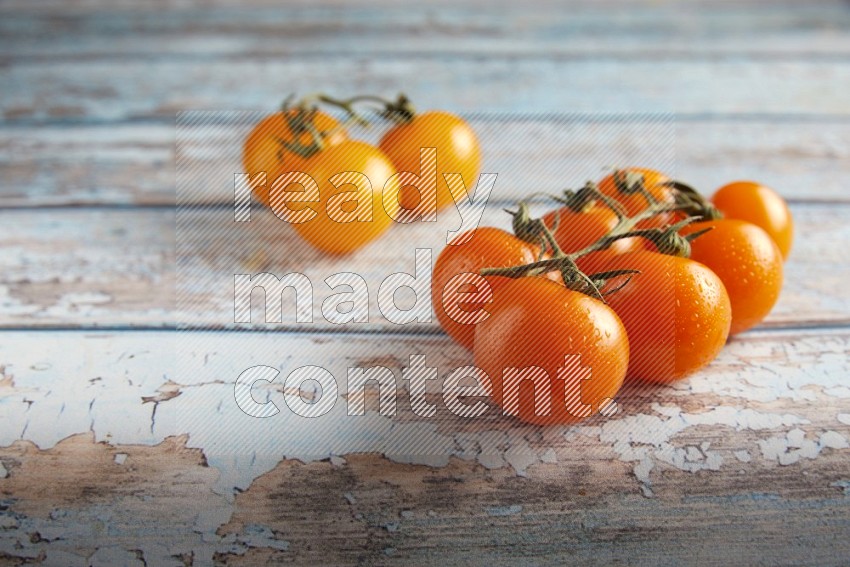 Mixed cherry tomato veins on a textured light blue wooden background 45 degree
