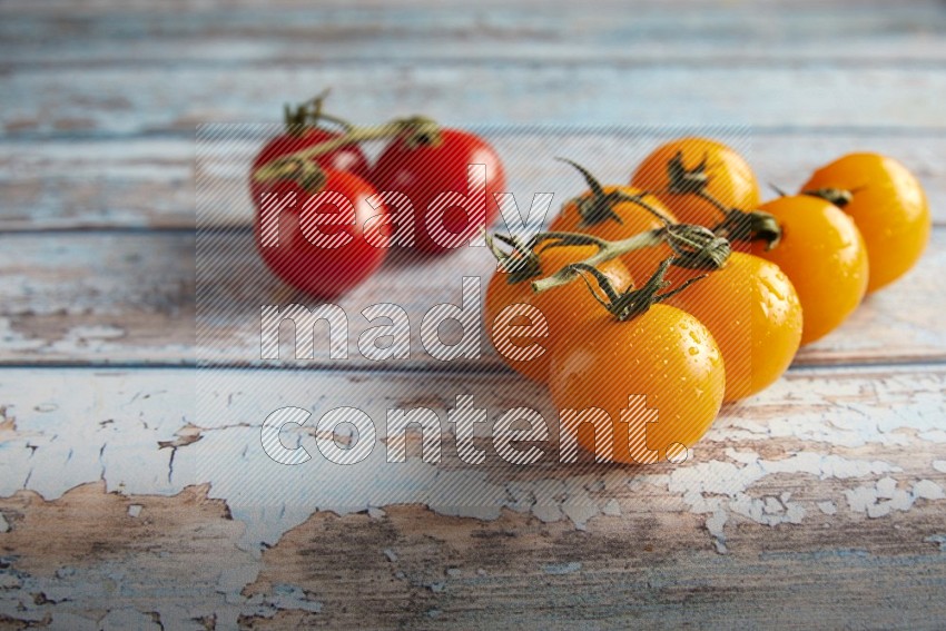 Mixed cherry tomato veins on a textured light blue wooden background 45 degree