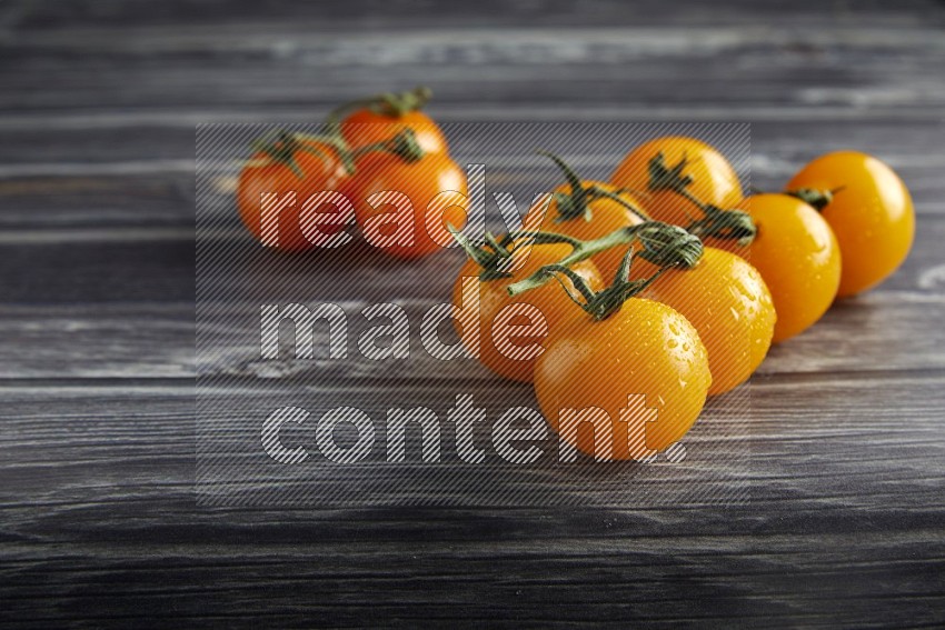 Mixed cherry tomato veins on a textured grey wooden background 45 degree