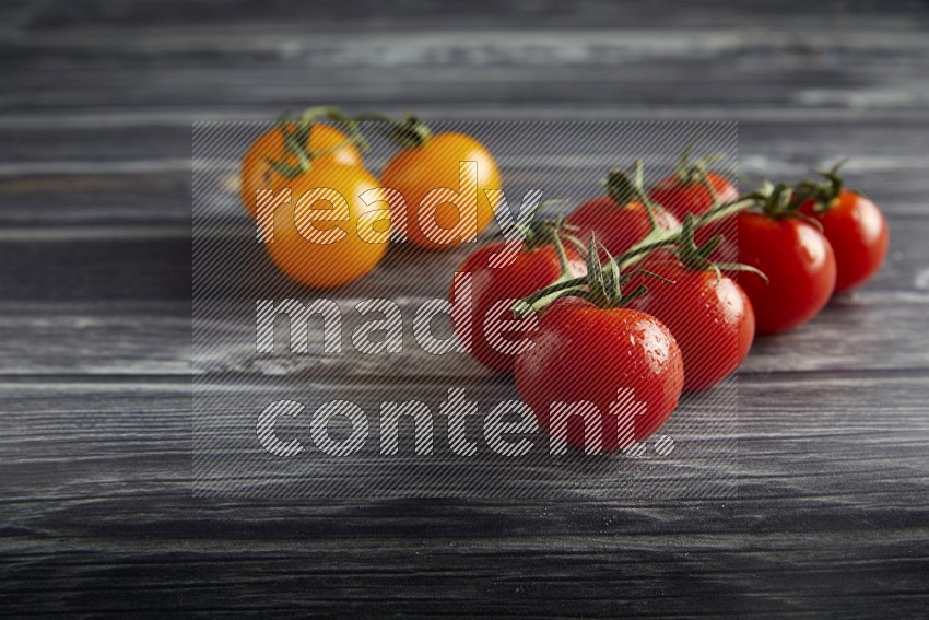 Mixed cherry tomato veins on a textured grey wooden background 45 degree